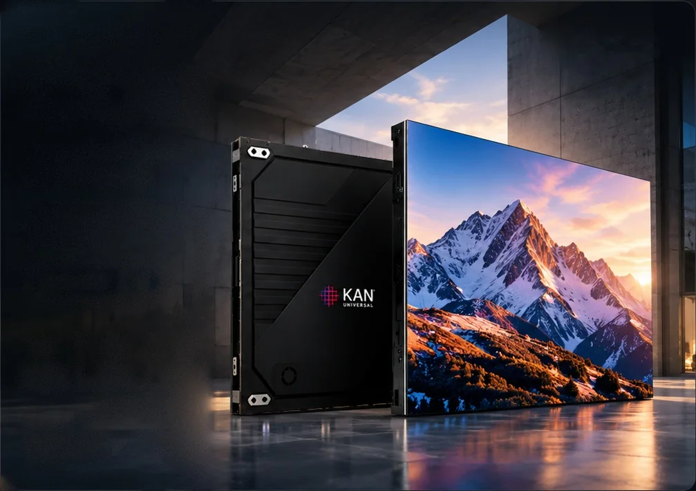 KAN Universal COB LED cabinet shown from the rear beside a seamless video wall displaying a sunlit mountain range in a concrete atrium
